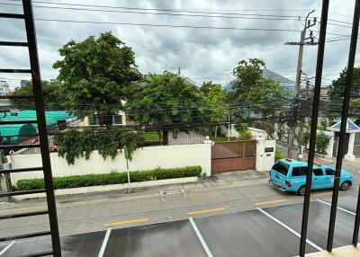 View from balcony overlooking street and parking area