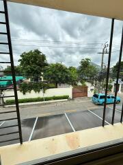 View from balcony overlooking street and parking area