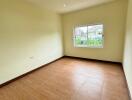 Spacious empty bedroom with wooden flooring and LED ceiling lights