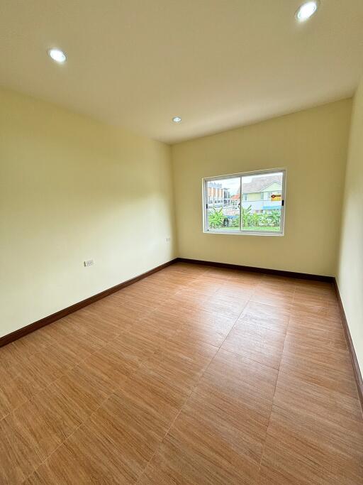 Spacious empty bedroom with wooden flooring and LED ceiling lights