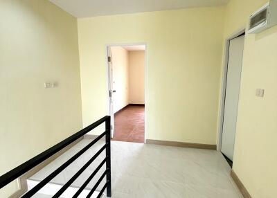 Bright hallway with lighting and handrail leading to rooms