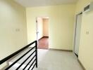 Bright hallway with lighting and handrail leading to rooms