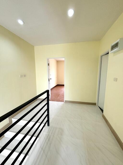 Bright hallway with lighting and handrail leading to rooms