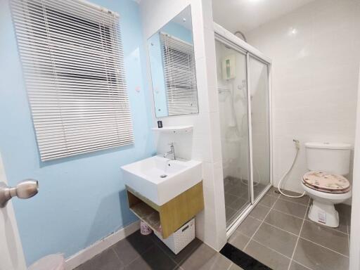 Modern bathroom with sink, mirror, shower, and toilet