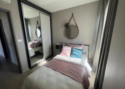 Modern bedroom with bed, mirror, and wardrobe