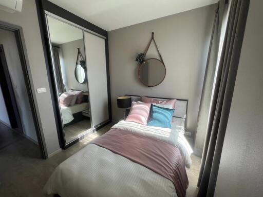 Modern bedroom with bed, mirror, and wardrobe