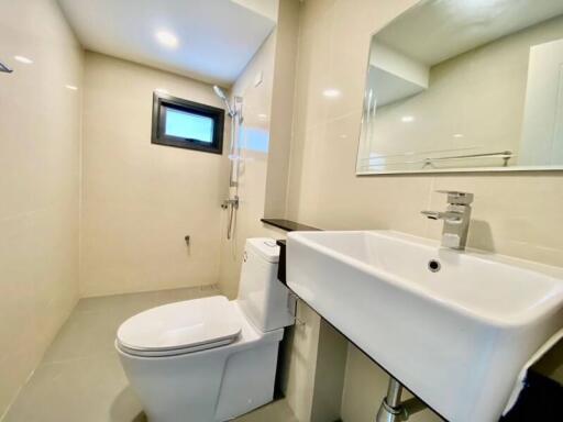 Modern bathroom with toilet, sink, and shower area