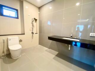 Modern bathroom with toilet, vanity, and shower