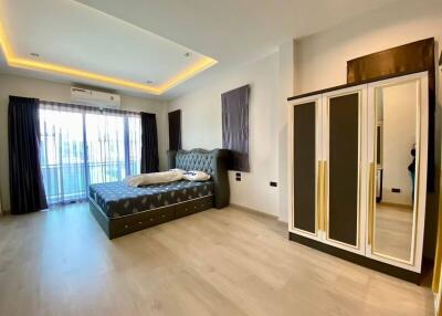 Modern and spacious bedroom with a large bed, mirrored wardrobe, and balcony access