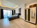 Modern and spacious bedroom with a large bed, mirrored wardrobe, and balcony access