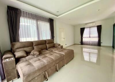 Spacious and bright living room with large windows and comfortable sectional sofa