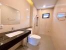 Modern bathroom with beige tiles, large mirror, and shower area