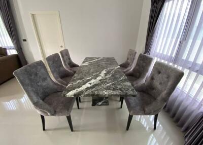 Dining area with marble table and upholstered chairs