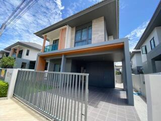 Modern two-story house exterior with garage and gate