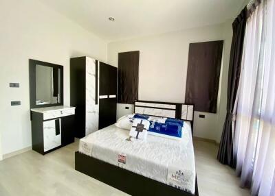 Modern furnished bedroom with bed, wardrobe, and vanity