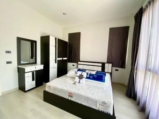 Modern furnished bedroom with bed, wardrobe, and vanity