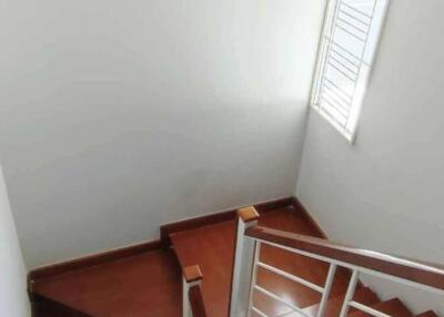 Interior view of a staircase with wooden steps and a window