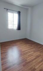 Empty bedroom with wooden floor and window