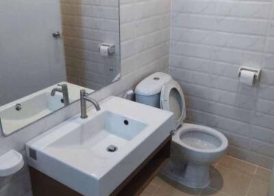 Modern bathroom with white fixtures and tiled walls