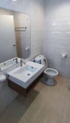 Modern bathroom with white fixtures and tiled walls