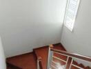 Well-lit staircase with wooden steps and a large window