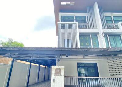 Modern three-story house with a carport in front