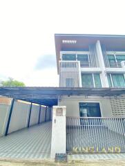 Modern three-story house with a carport in front