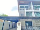 Modern three-story house with a carport in front