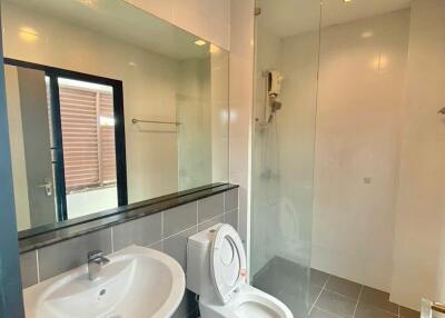 Modern bathroom with sink, toilet, and large mirror