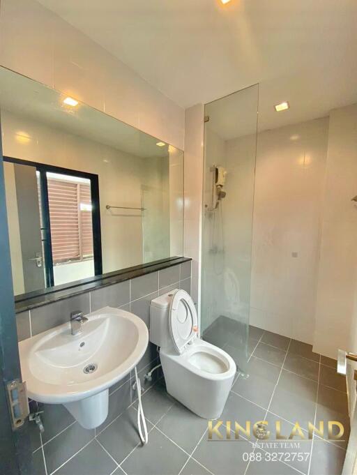 Modern bathroom with sink, toilet, and large mirror