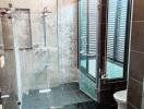 Modern bathroom with glass shower enclosure and black tile flooring