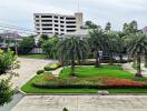 View from the property showing green landscaped gardens with trees and a building in the background