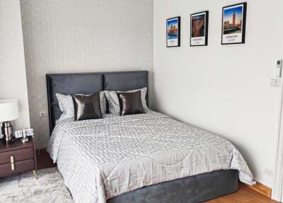 Modern bedroom with bed, bedside table, and framed pictures