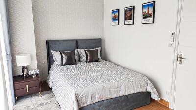 Modern bedroom with bed, bedside table, and framed pictures