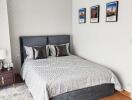 Modern bedroom with bed, bedside table, and framed pictures