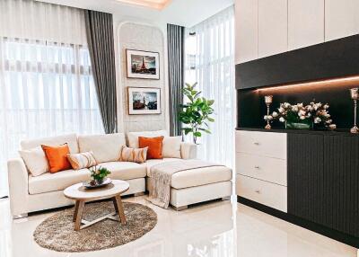 Modern living room with white sofa, orange cushions, and decorative plants