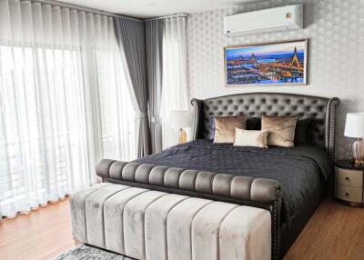 Modern and elegant bedroom with large bed, nightstands, and air conditioning