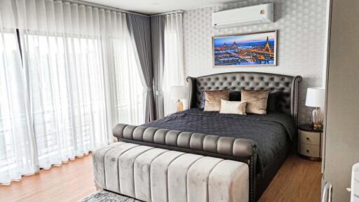 Modern and elegant bedroom with large bed, nightstands, and air conditioning