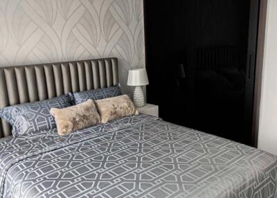 Modern bedroom with patterned bedding and textured wallpaper