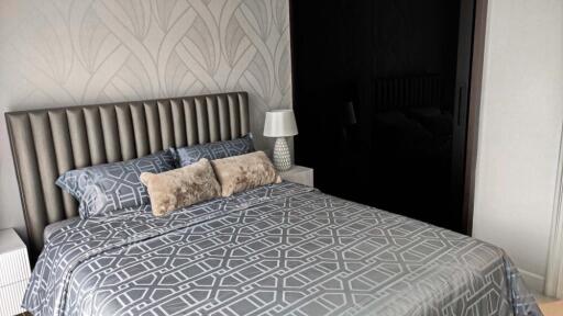 Modern bedroom with patterned bedding and textured wallpaper