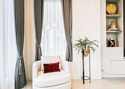 Modern living room with chair, plant, and decorative shelving