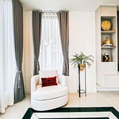 Modern living room with chair, plant, and decorative shelving