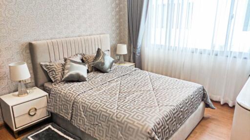 Modern bedroom with patterned wallpaper and grey decor