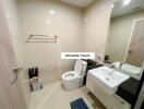 Modern bathroom with toilet, sink, mirror, and towel rack