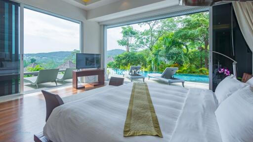 Spacious bedroom with large windows and outdoor pool view