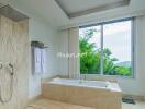 modern bathroom with a bathtub and large window