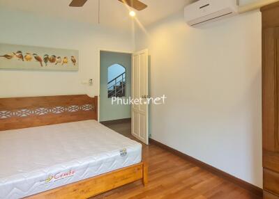 Main bedroom with wooden bed frame, mattress, and wardrobe