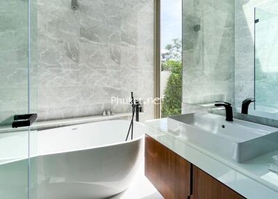 Modern bathroom with freestanding bathtub and white countertop sink