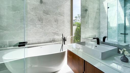 Modern bathroom with freestanding bathtub and white countertop sink