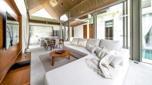 Modern living room with sectional sofa, wooden accents, and large windows